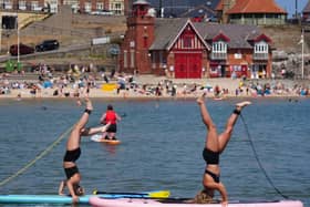 Paddleboarders Olivia Selby, 20, and her sister Abbie Selby, 17, enjoying the hot weather on the coast at Cullercoats Bay in North Tyneside