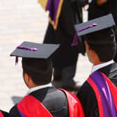 The backs of students in graduation hats and gowns