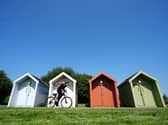 A cyclist passes huts on the Forth & Clyde Canal in Falkirk.