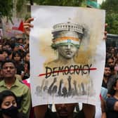 A supporter of the Cockroach Janta Party holds a placard during a protest