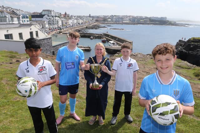 The Mayor of Causeway Coast and Glens Borough Council, Councillor Dawn Huggins, is pictured with Rohan Roy and Ronan O'Donnell from Maiden City, and Levi Weir and Archie Muir from Ballymena United, who will compete in the Minor Section of the 2026 Budget Energy SuperCupNI.