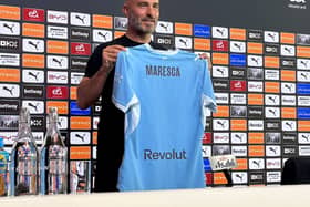 Manchester City manager Enzo Maresca holds up a club shirt with his name on during his introductory press conference