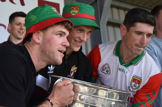 Jordan Flynn, Kobe McDonald and Conor Loftus lifting the Sam Maguire trophy at homecoming in Crossmolina