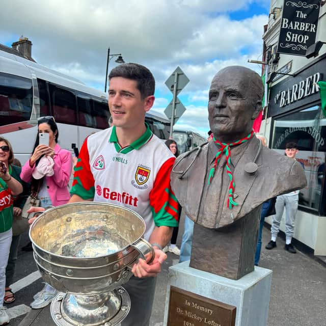 Conor Loftus holding the Sam Maguire trophy beside the Dr Mickey Loftus statue