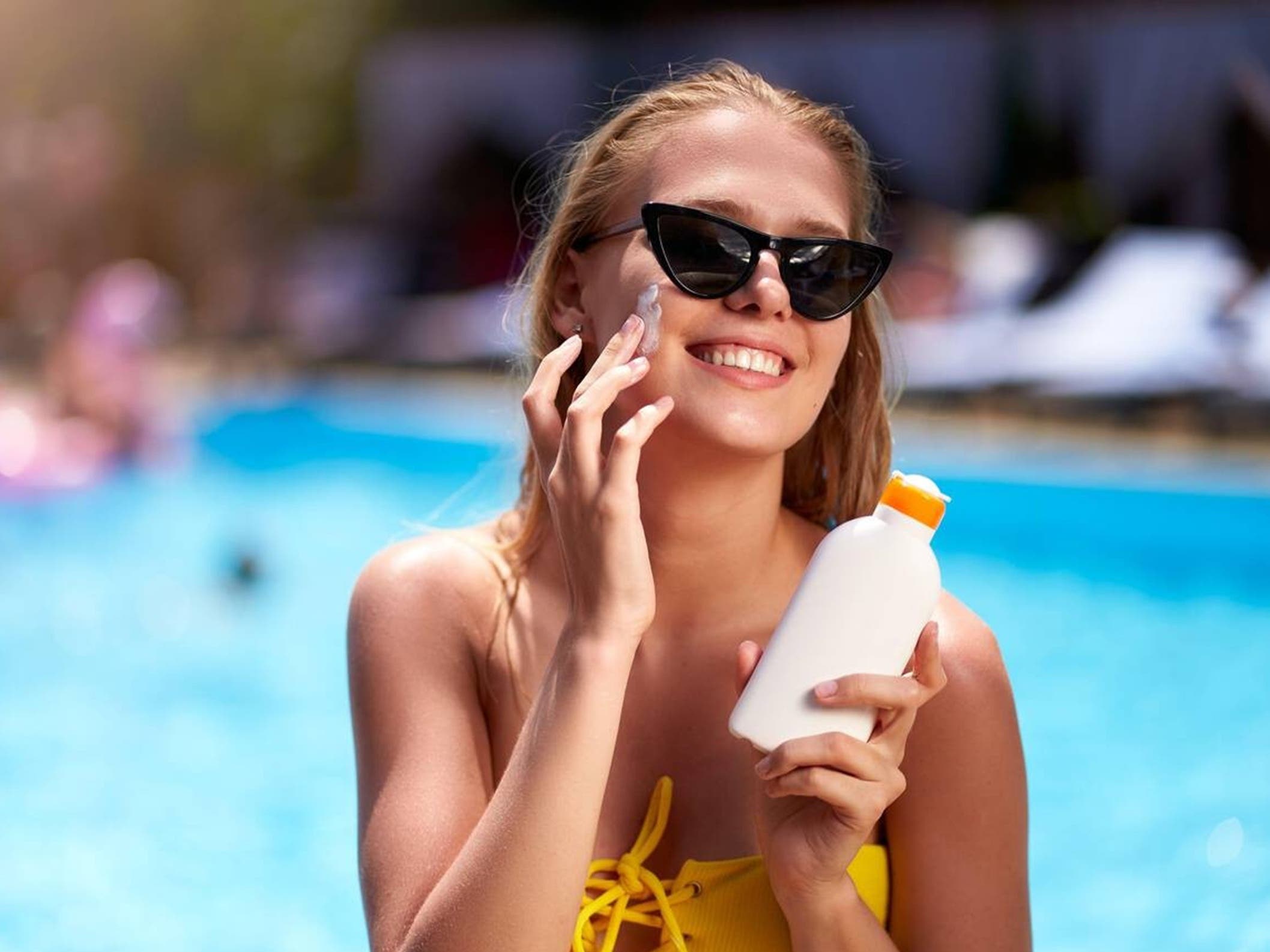 Woman applying sunscreen on her face