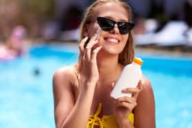 Woman applying sunscreen on her face