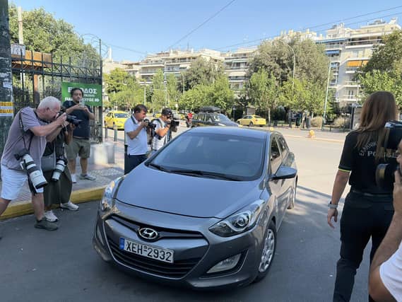 Photographers surrounding a grey car