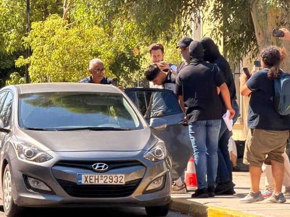 Sharif Ahmadzai is escorted into a car
