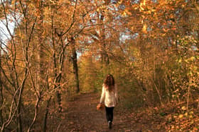 Casual woman walking in colourful park (Alamy/PA)
