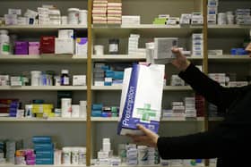 A pharmacist putting medicines in a paper bag