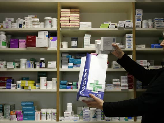 A pharmacist putting medicines in a paper bag