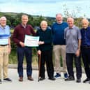 Henry McLaughlin handing over a cheque for £3,905 to Lee Casey, the proceeds of the Concern Worldwide Scalp Walk. Included on left, is Eunan O'Donnell, and from right, Ciaran Keaveney, Laurence  Hegarty and Tommy McDermott.  