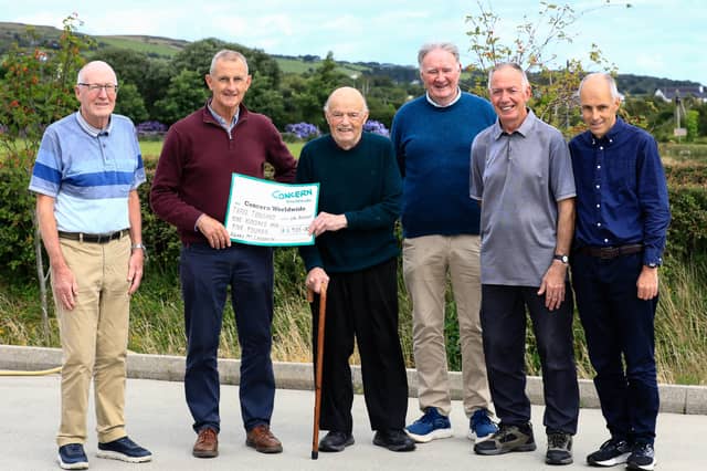 Henry McLaughlin handing over a cheque for £3,905 to Lee Casey, the proceeds of the Concern Worldwide Scalp Walk. Included on left, is Eunan O'Donnell, and from right, Ciaran Keaveney, Laurence Hegarty and Tommy McDermott.