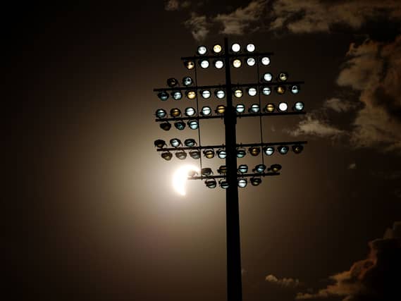 A view of the eclipse, as the Moon passes between the Earth and the Sun behind a flood light during The Hundred men’s match at Edgbaston, Birmingham