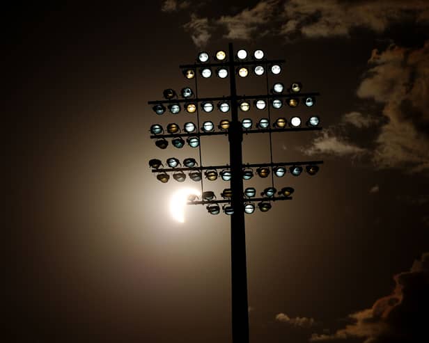A view of the eclipse, as the Moon passes between the Earth and the Sun behind a flood light during The Hundred men’s match at Edgbaston, Birmingham