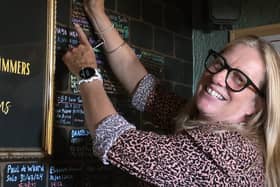 Grace McLaughlin smiling while signing her name on a board