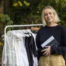 Ciara Tinney smiling, standing next to a rack of clothing