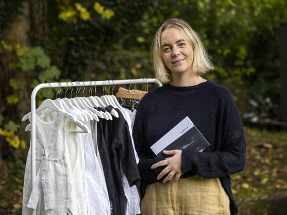 Ciara Tinney smiling, standing next to a rack of clothing