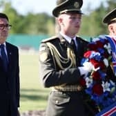 Andy Burnham behind a Ukrainian soldier carrying a wreath with the Union Jack on it