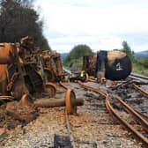 Burned out fuel wagons on a damaged railway line