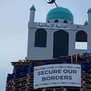A bonfire with a model of a mosque on top of it