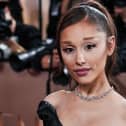 Ariana Grande wearing an off the shoulder black gown with her hair in a ponytail