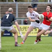 Magherafelt's Conall Higgins with Conor Coyle of Slaughtneil closing in during last week's Derry Senior Football Championship match at Owenbeg. 