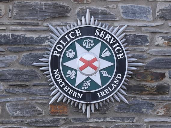 A Police Service of Northern Ireland badge on a wall outside a station
