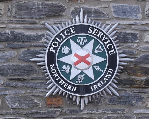 A Police Service of Northern Ireland badge on a wall outside a station
