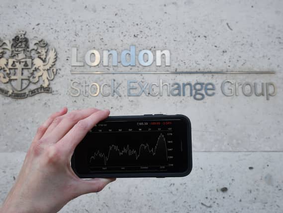 A view of the Stocks app on an iPhone against the London Stock Exchange sign in the City of London, as the FTSE 100 Index crashed on opening by more than 230 points to 7,104.94 as inflation fears continue to rock global markets