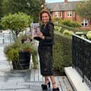 Left: The front cover of my memoir, Glamour & Grit, featuring me posing by the river front. Right: Having a flick through the pages of the book to make sure it meets my standards!