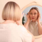 Woman adjusting face in mirror