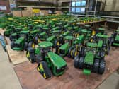 A view of dozens of green and yellow John Deere tractor toys