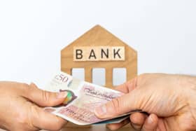 Bank in background with hands exchanging money