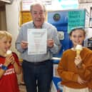 Aidan Byrnes with his certificate as the Leinster Express Readers' Choice Best '99 in Laois 2026, with happy young customers Adam Powala and Lucy O'Brien.