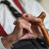 An old man's hands on a walking stick
