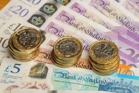 Close-up of British pound coins resting on pound notes