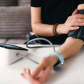 Woman Measuring Blood Pressure With A Digital Monitor at home