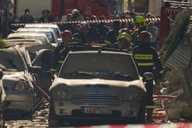 Firefighters work at the scene following a powerful blast that caused a building to collapse and injured at least two people in Athens’ Plaka district