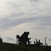 Silhouette of a protester sitting against a grey sky