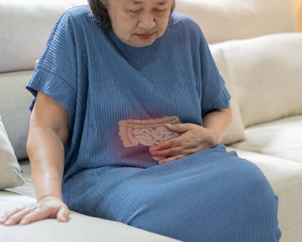Older mature man holding drawing of digestion system over her bowel