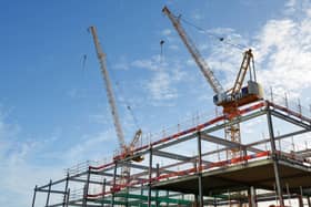 Steel frame and two cranes on a construction site