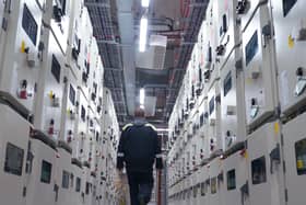 A man seen from behind walking inside data centre
