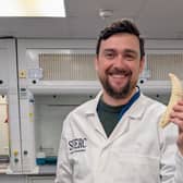 Dr Kieran Tierney holding a whale tooth