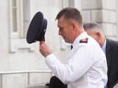 Garda Commissioner Justin Kelly removes his hate while walking outside