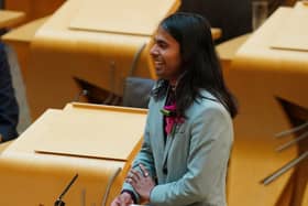 Side view of Q Manivannan standing in the main Holyrood chamber