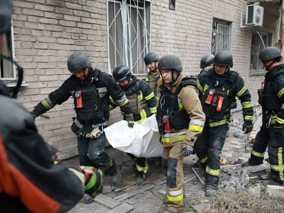 Rescue workers carry a body from the rubble of a residential building