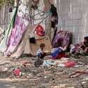 A displaced Yemeni family sits beside a makeshift shelter along a roadside in Aden, Yemen