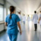 Blurred figures of doctors and nurses walking in a hospital corridor
