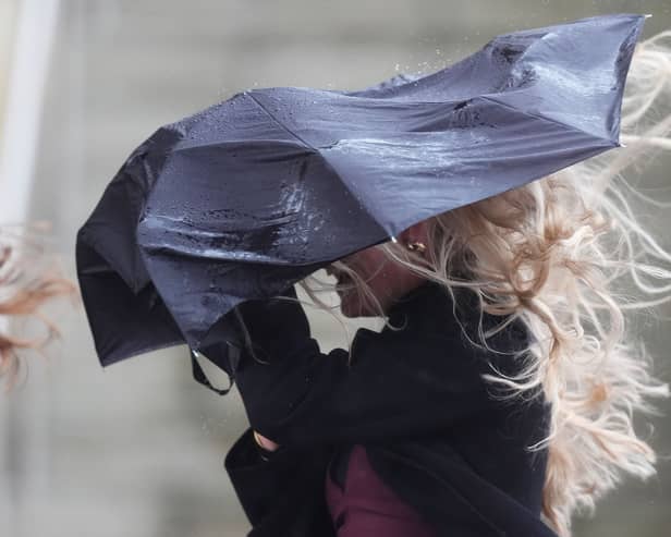 Strong wind blowing an umbrella held by woman